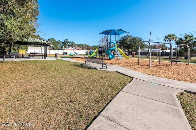 community play area with fence and a yard