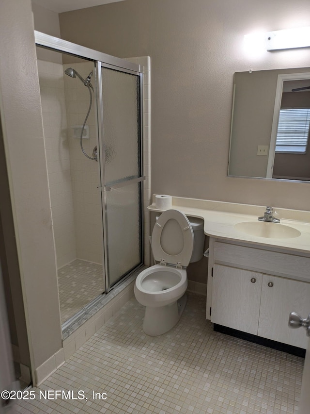 full bath featuring toilet, a shower stall, vanity, and tile patterned floors