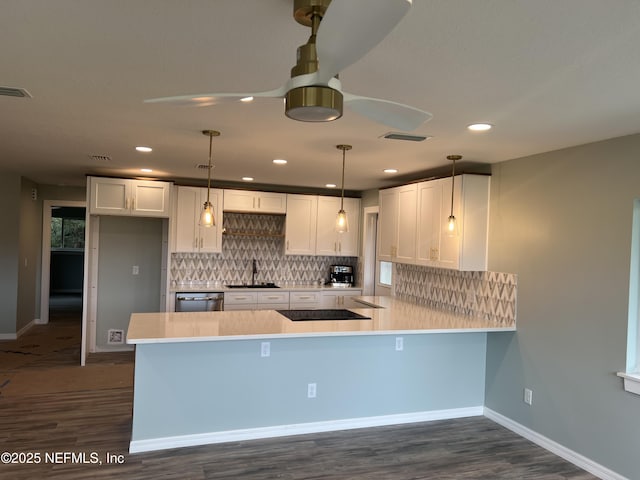 kitchen with a peninsula, hanging light fixtures, light countertops, and white cabinets