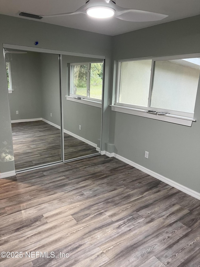 716 Grand Rondo W, Crescent City, FL 32112 - unfurnished bedroom featuring baseboards, wood finished floors, a closet, and a ceiling fan