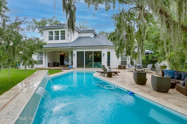 back of house featuring a yard, an outdoor pool, a patio, and a shingled roof