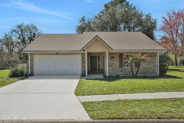 view of front of home with an attached garage, a shingled roof, a front lawn, and concrete driveway