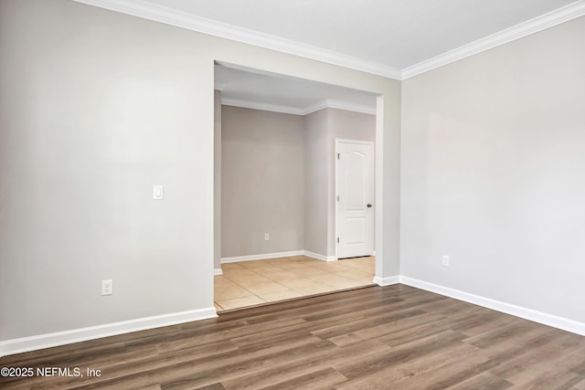 unfurnished room featuring crown molding, baseboards, and wood finished floors