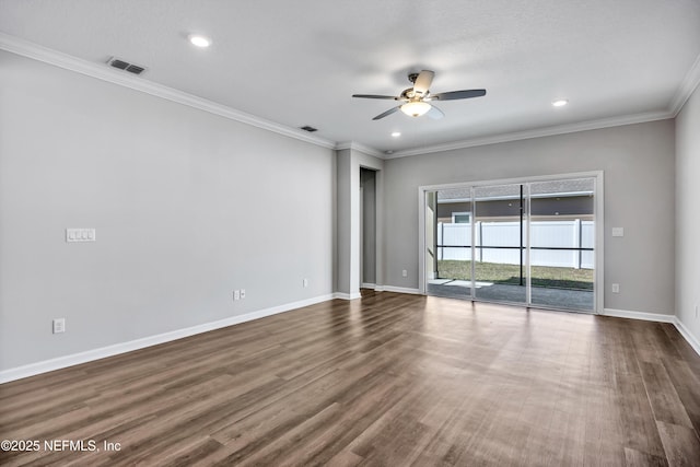 spare room with ceiling fan, wood finished floors, visible vents, baseboards, and ornamental molding