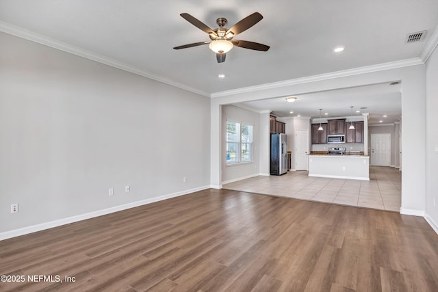 unfurnished living room featuring visible vents, baseboards, a ceiling fan, light wood-style flooring, and ornamental molding