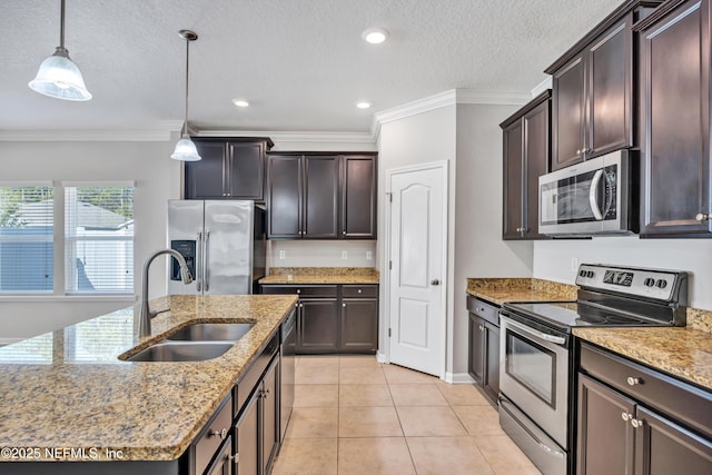 kitchen featuring pendant lighting, crown molding, appliances with stainless steel finishes, a kitchen island with sink, and a sink