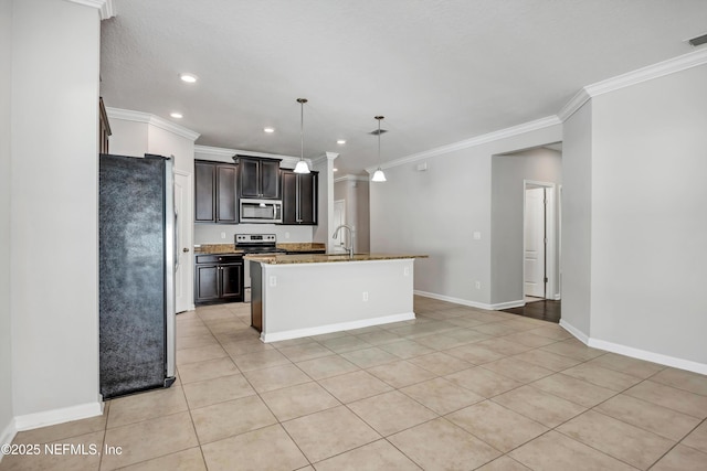 kitchen with light stone counters, decorative light fixtures, stainless steel appliances, a sink, and a center island with sink