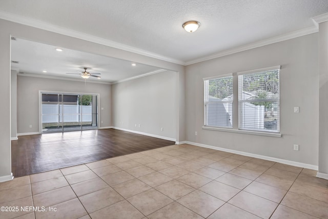 empty room with light tile patterned floors, a wealth of natural light, and crown molding