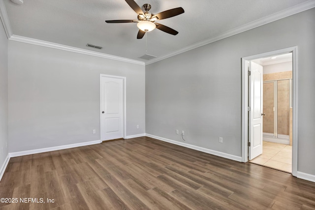 unfurnished bedroom featuring baseboards, visible vents, wood finished floors, and ornamental molding