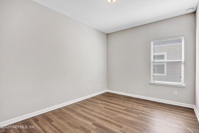 unfurnished room with wood finished floors and baseboards