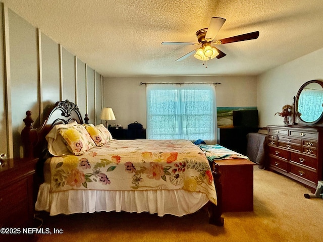 bedroom with light carpet, ceiling fan, and a textured ceiling