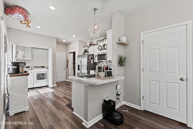 kitchen with dark wood-style floors, appliances with stainless steel finishes, white cabinetry, a peninsula, and baseboards