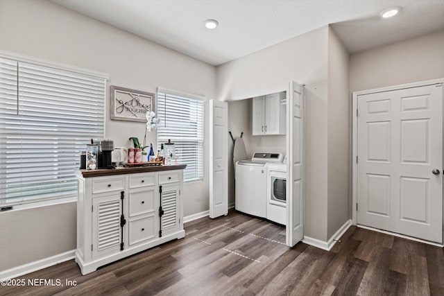 washroom with dark wood-style floors, baseboards, washer and clothes dryer, and cabinet space