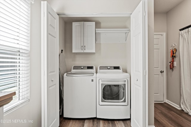 laundry area with dark wood-style flooring, independent washer and dryer, cabinet space, and baseboards