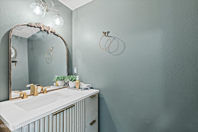 bathroom with vanity and a textured wall