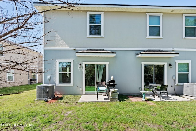 back of property featuring a patio area, a lawn, central AC, and stucco siding