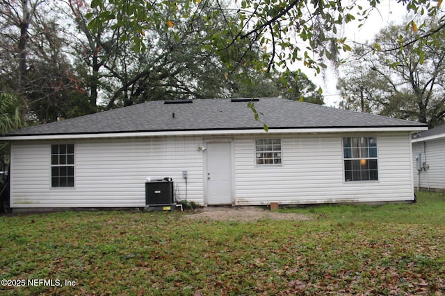 back of house featuring central air condition unit and a yard