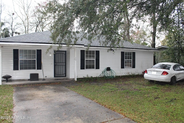 view of front of house with a front lawn and roof with shingles