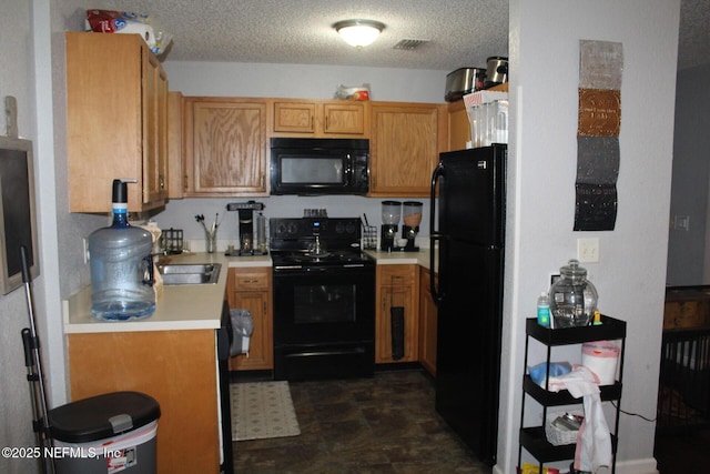 kitchen featuring visible vents, light countertops, a textured ceiling, black appliances, and a sink