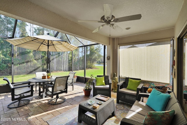 sunroom / solarium featuring a ceiling fan