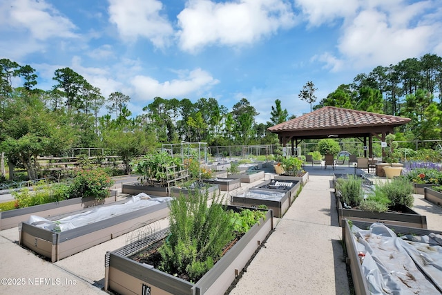 view of community with fence, a vegetable garden, and a gazebo