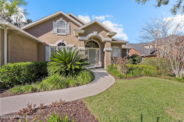 mediterranean / spanish-style home featuring a front yard and stucco siding