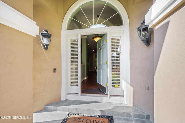 view of exterior entry featuring stucco siding