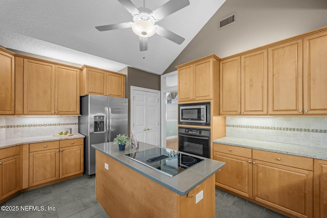 kitchen with tasteful backsplash, visible vents, a kitchen island, vaulted ceiling, and black appliances