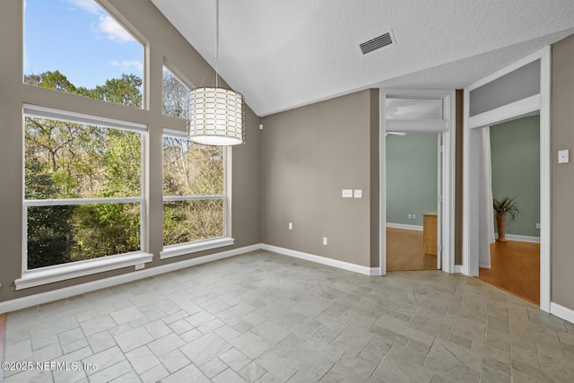 interior space featuring lofted ceiling, visible vents, stone finish floor, a textured ceiling, and baseboards