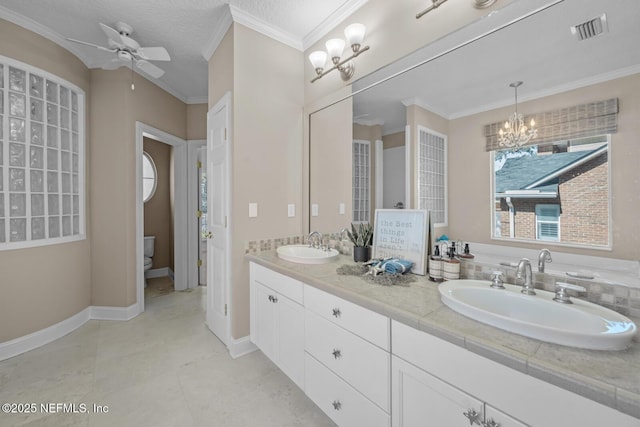 bathroom featuring ornamental molding, a sink, and visible vents