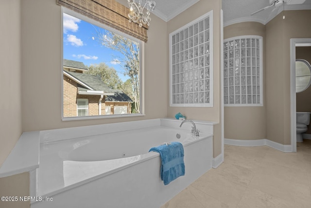 bathroom with a garden tub, crown molding, a notable chandelier, toilet, and baseboards