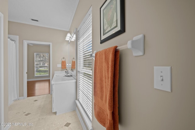 bathroom with visible vents, ornamental molding, vanity, and a healthy amount of sunlight