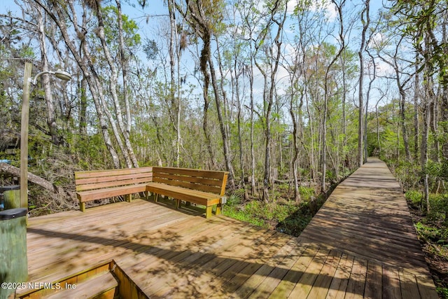 exterior space with a forest view and a wooden deck