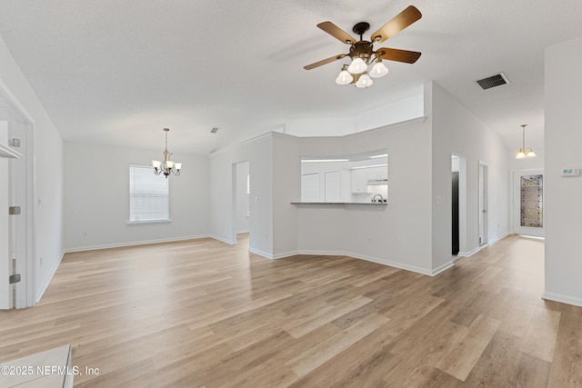 unfurnished living room with visible vents, baseboards, light wood-style flooring, a textured ceiling, and ceiling fan with notable chandelier