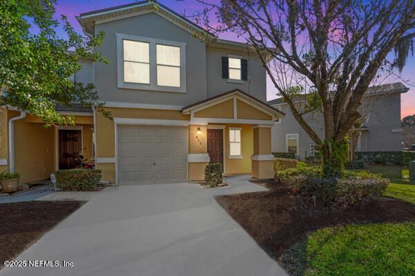 view of front of home featuring a garage, concrete driveway, and stucco siding