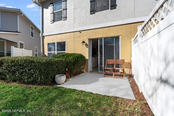 back of property featuring a patio, a yard, and fence