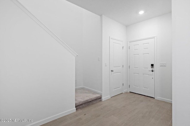 foyer entrance with light wood-style floors, recessed lighting, and baseboards