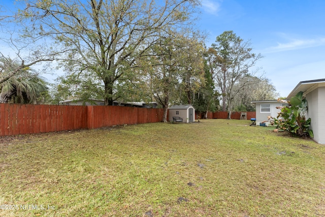 view of yard featuring a storage shed, an outdoor structure, and a fenced backyard