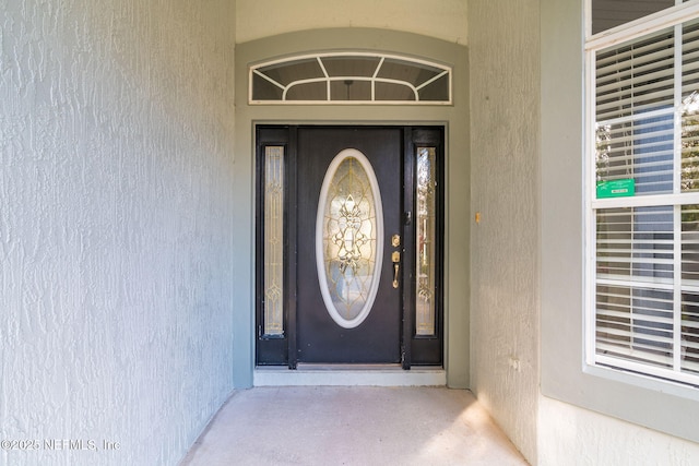 view of exterior entry featuring stucco siding