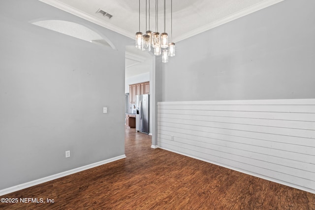 empty room featuring a chandelier, visible vents, baseboards, dark wood finished floors, and crown molding