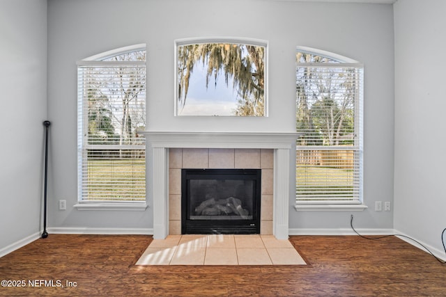 details featuring a fireplace, baseboards, and wood finished floors