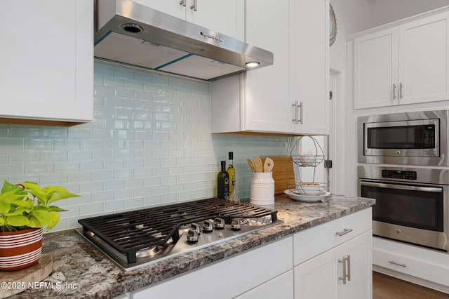 kitchen with white cabinets, stainless steel appliances, extractor fan, stone counters, and backsplash