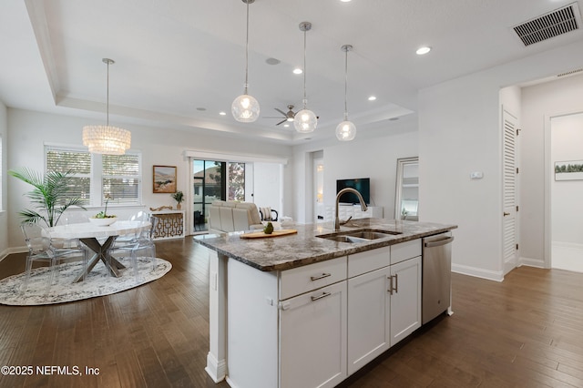 kitchen with a sink, visible vents, open floor plan, stainless steel dishwasher, and a raised ceiling