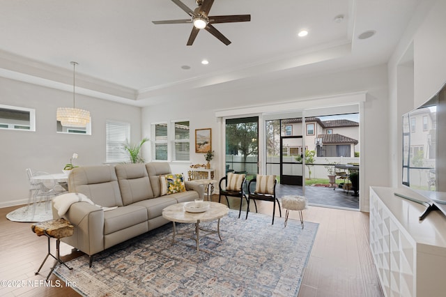 living room featuring recessed lighting, a raised ceiling, and wood-type flooring