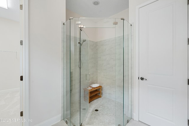 full bath with a stall shower and baseboards