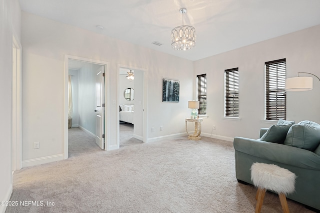 living area featuring carpet floors, baseboards, visible vents, and a notable chandelier