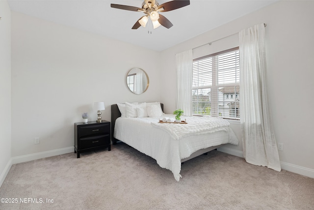 bedroom featuring light colored carpet, ceiling fan, and baseboards