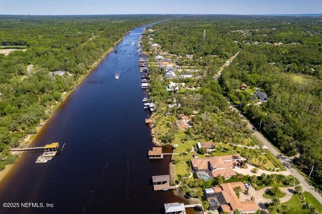 drone / aerial view featuring a water view and a wooded view