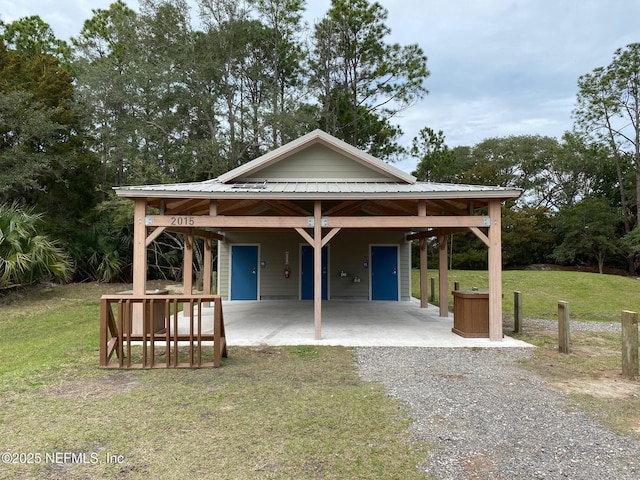 exterior space featuring a yard, a carport, and gravel driveway