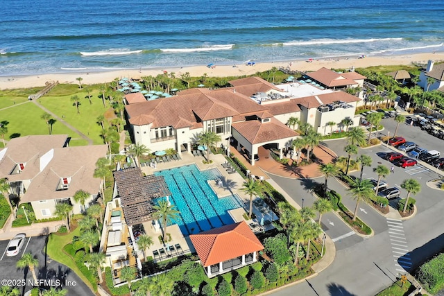 drone / aerial view featuring a water view, a residential view, and a view of the beach